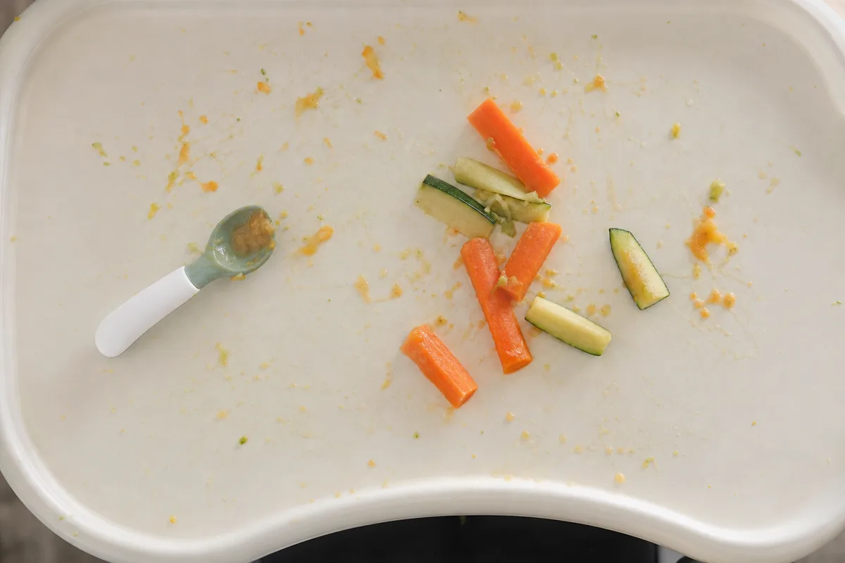 Plateau de chaise haute vu du dessus avec bâtonnets de légumes cuits